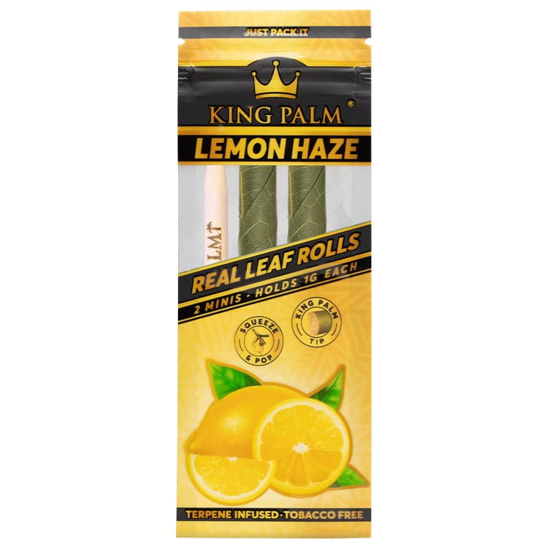 Auf der Verpackung steht „King Palm Lemon Haze“. Zwei grüne Mini-Rollen sind in einem durchsichtigen Fenster sichtbar. Unten sind Zitronen abgebildet. Es steht „Real Leaf Rolls, 2 Minis, hält 1g jede, Terpene Infused, Tobacco Free“ drauf. Die Verpackung ist gelb, schwarz und zeigt ein Kronenlogo. Symbole für „Squeeze & Pop“ und „King Palm Tip“ sind ebenfalls zu sehen.